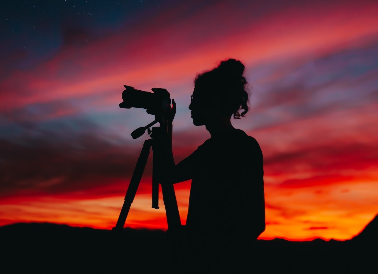 Woman at sunset with a camera