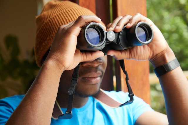 Man with binoculars near the window