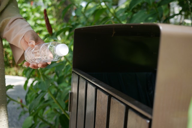 Putting a plastic bottle in the recycling bin